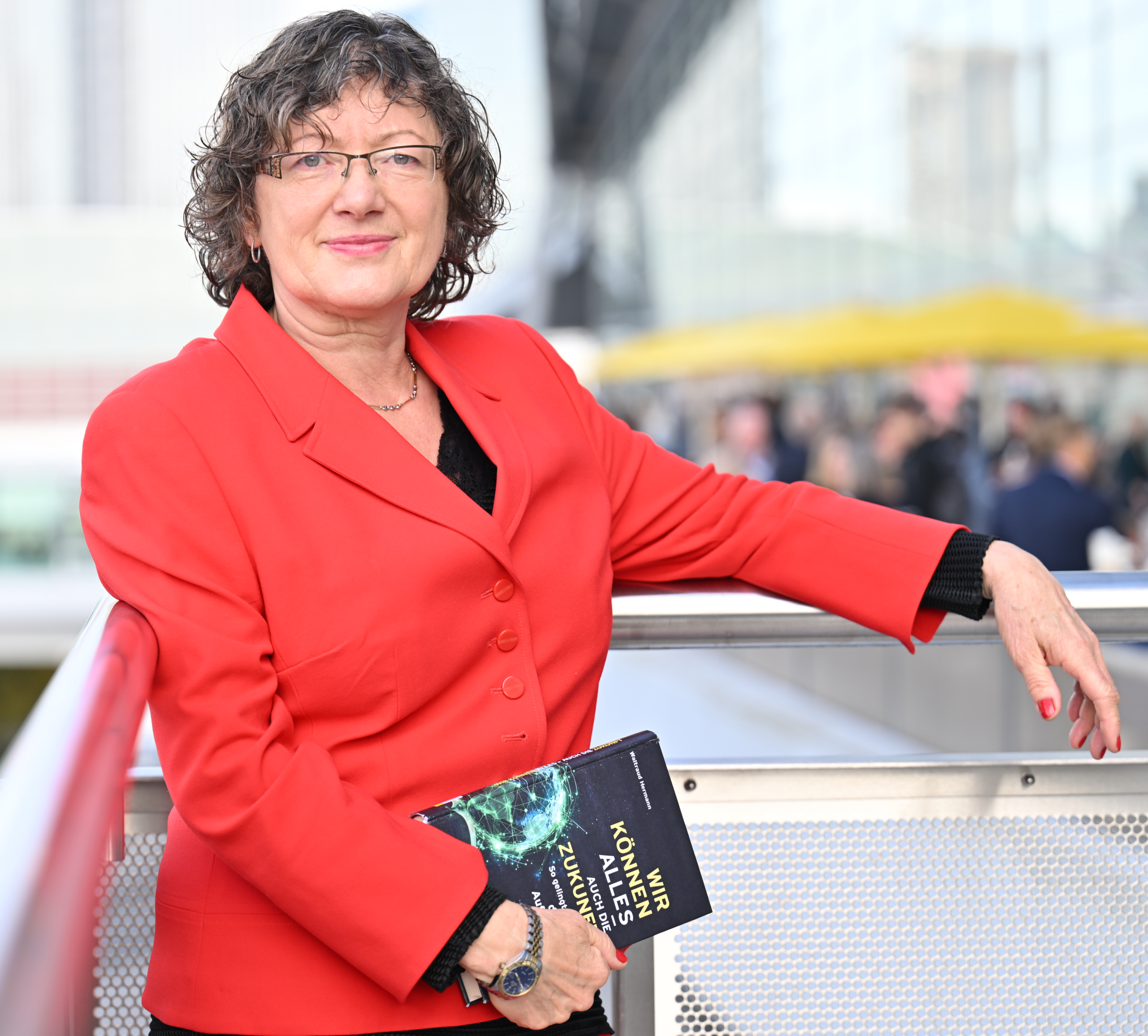 Waltraud Herrmann – digitale Souveränität Waltraud Hermann, Expertin für digitale Souveränität, mit Buch auf einer Empore der Frankfurter Buchmesse